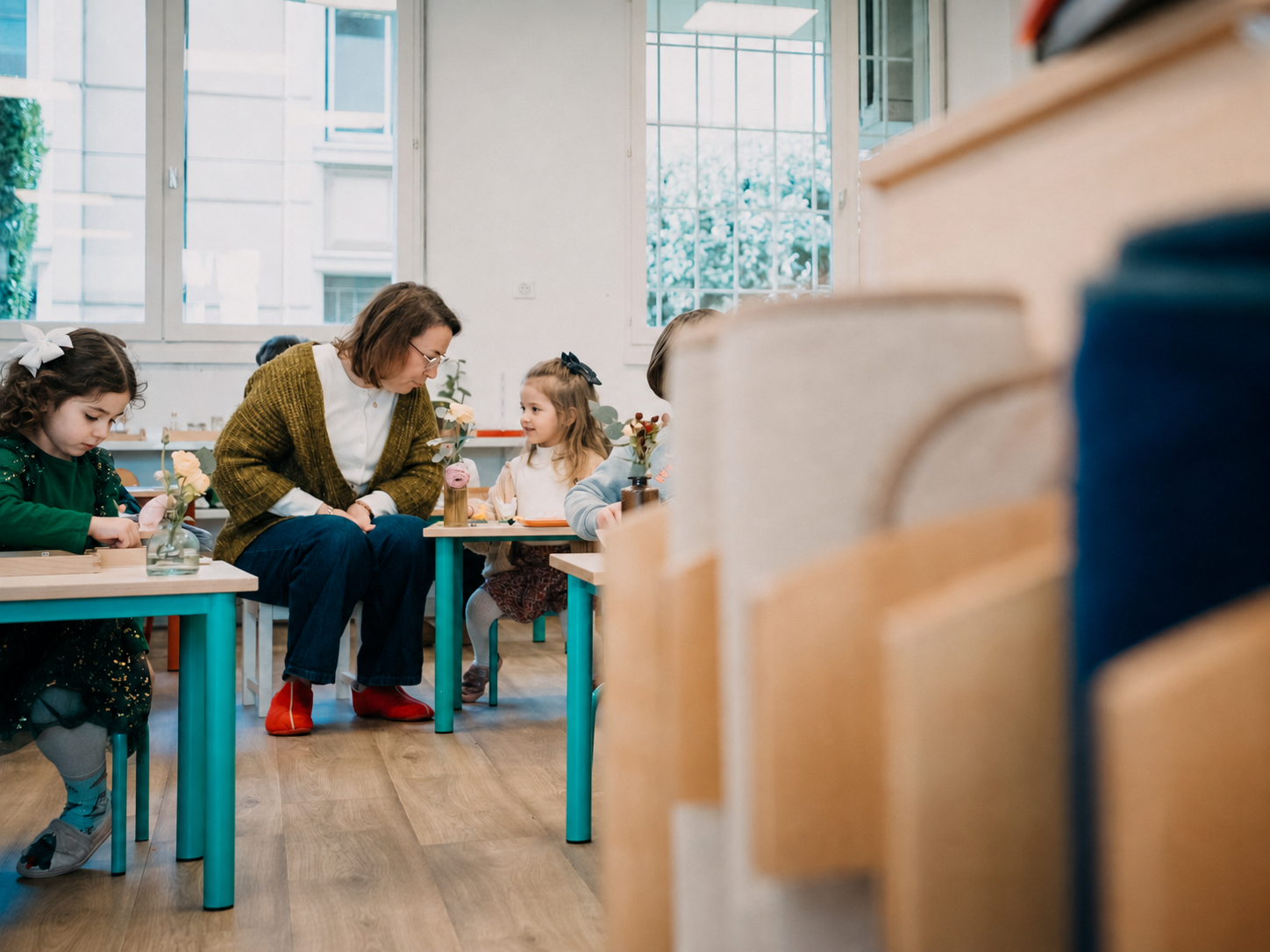Une éducatrice accompagne un enfant sur une activité, dans la classe